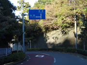 元町方面から一周道路を北進すると出てくる道路標識。左折が岡田港。直進して泉津方面へ